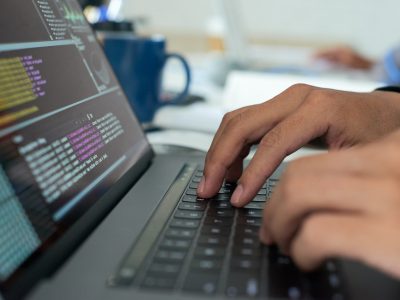 Working on code Hands of programmer writing code on laptop